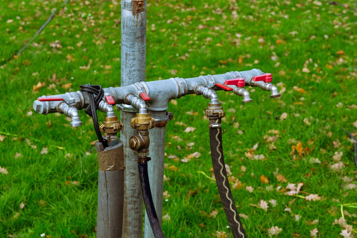 Several hose connections attached to a metal pole on a supply manifold